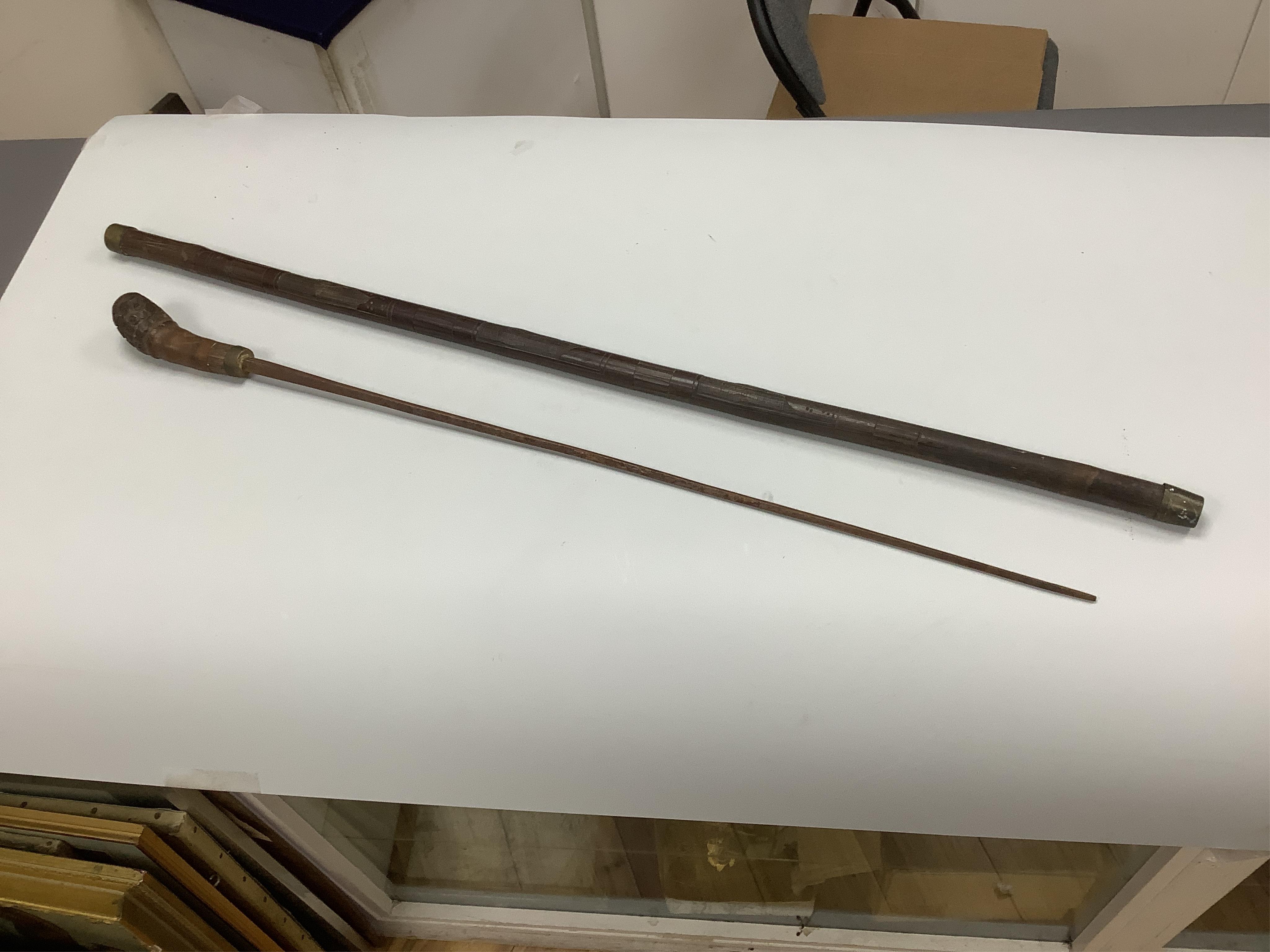 An officer’s sword, three walking sticks and an antique sword stick, longest walking stick 92cm long
